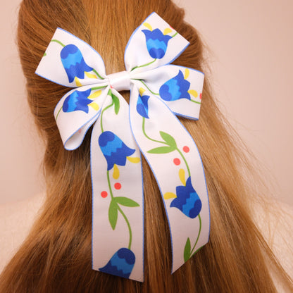 Baltas kaspinukas su mėlynomis gėlėmis