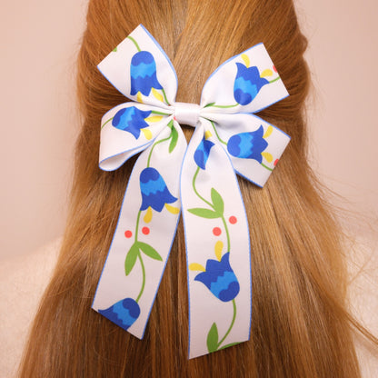 Baltas kaspinukas su mėlynomis gėlėmis