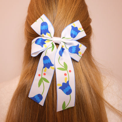 Baltas kaspinukas su mėlynomis gėlėmis